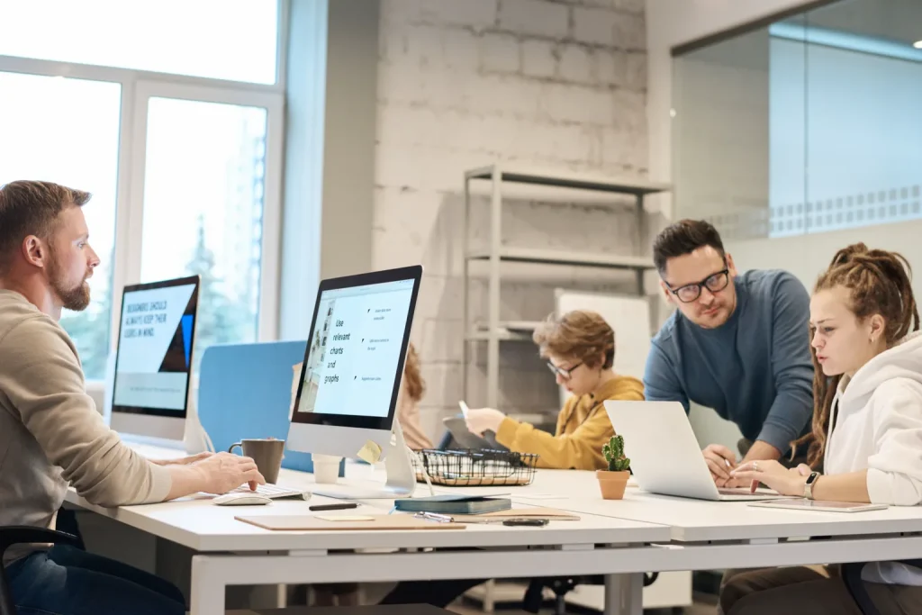 Equipo profesional analiza opciones alrededor de una mesa de trabajo