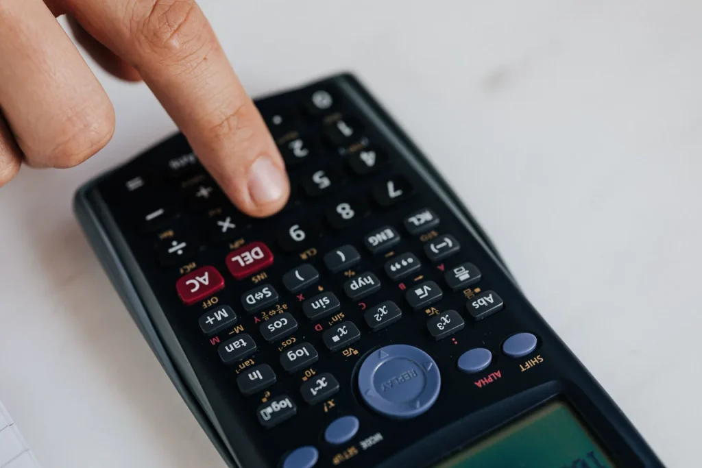 Persona calcula ingresos y organiza dinero sobre una mesa de trabajo