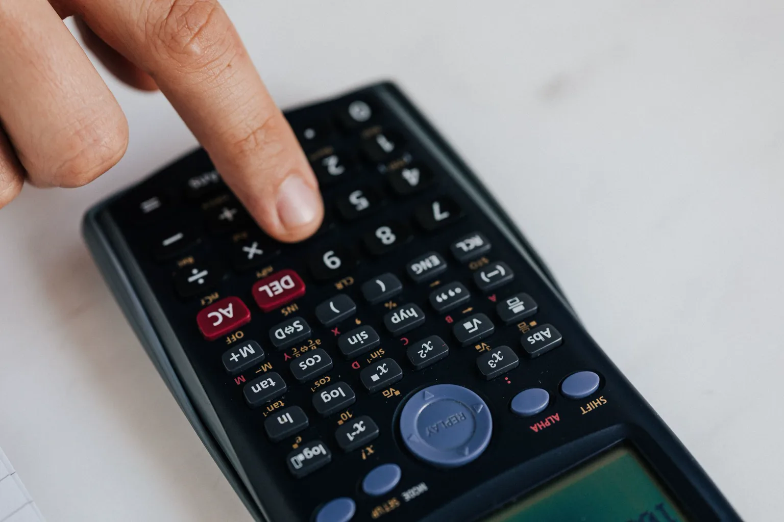 Persona calcula ingresos y organiza dinero sobre una mesa de trabajo