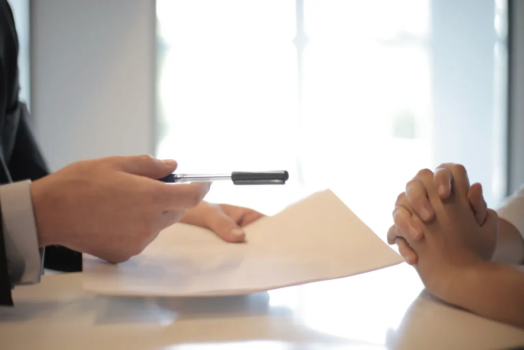 Profesional cansada frente a un escritorio con documentos y computadora