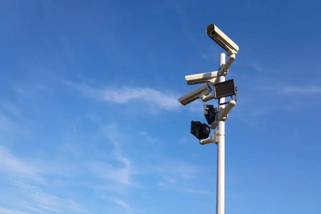 Varias cámaras de vigilancia instaladas en un poste bajo el cielo azul