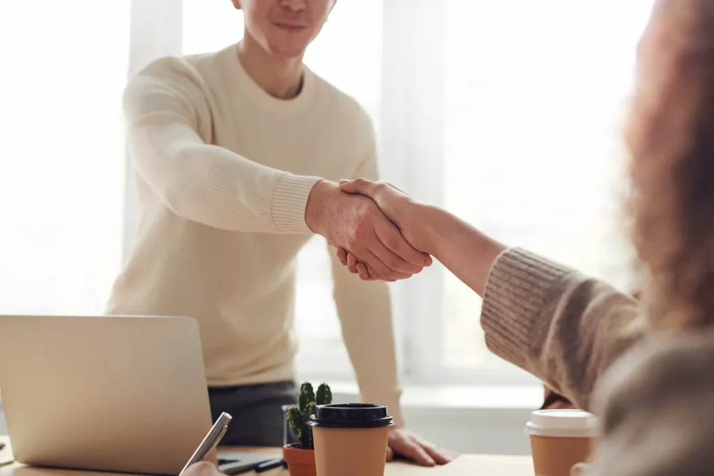 Dos profesionales conversan frente a frente durante una reunión de trabajo