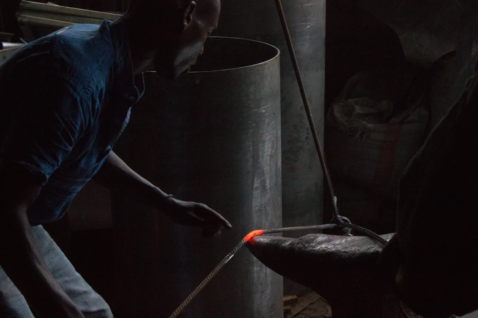 Trabajador en un taller de metal junto a una pieza calentada, imagen que representa capacidad operativa y ritmo de producción