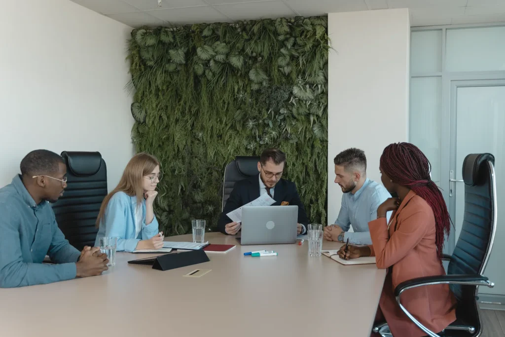 Equipo profesional conversa alrededor de una mesa durante una reunión de trabajo