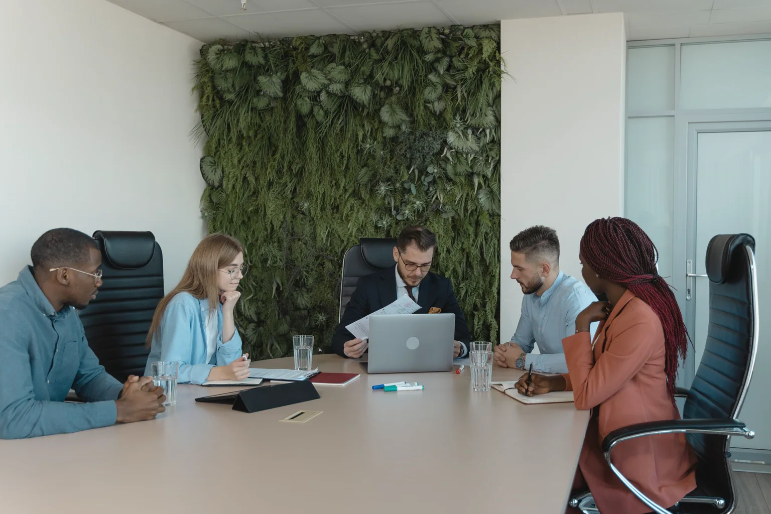 Equipo profesional conversa alrededor de una mesa durante una reunión de trabajo