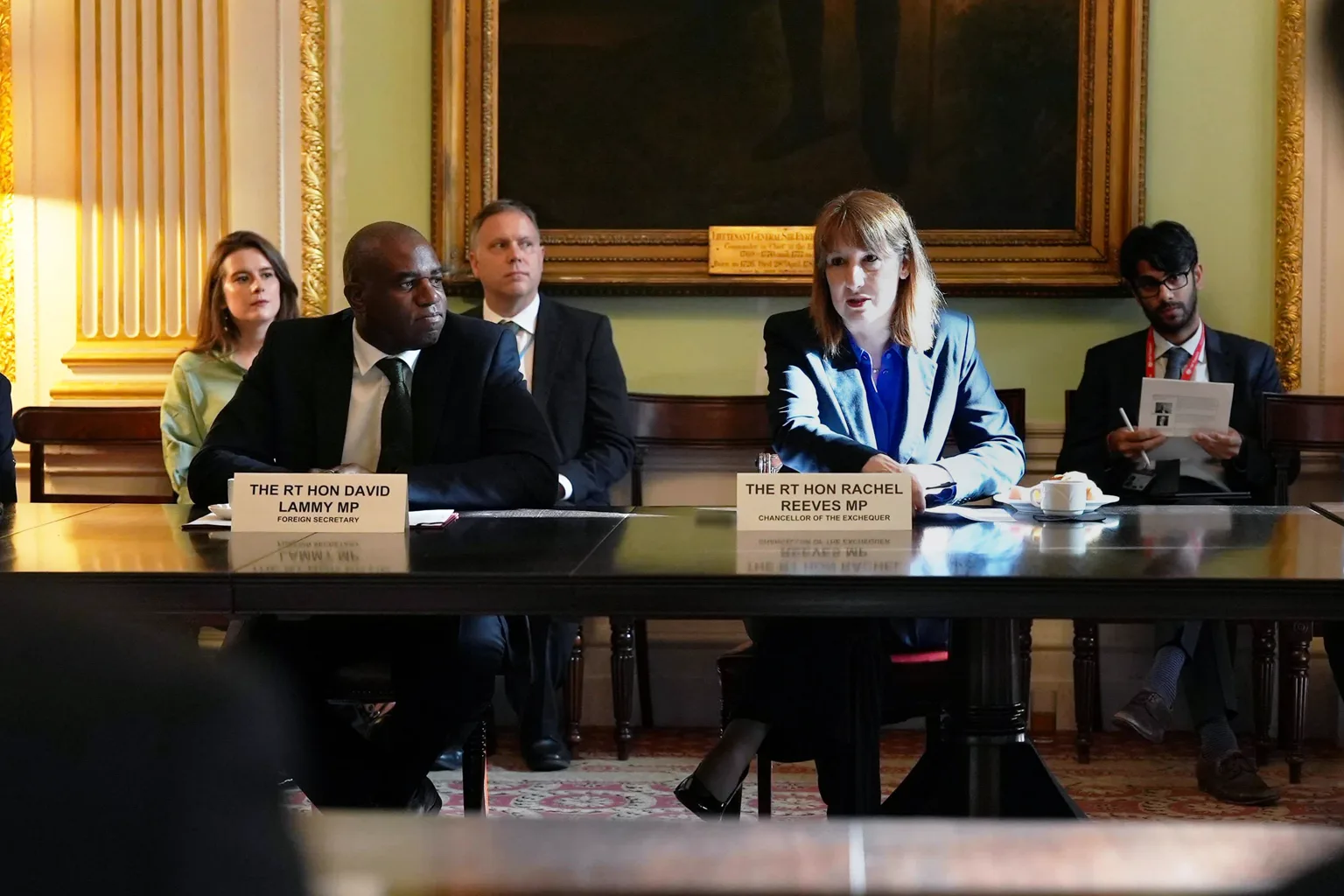 Personas conversan en una reunión de trabajo alrededor de una mesa