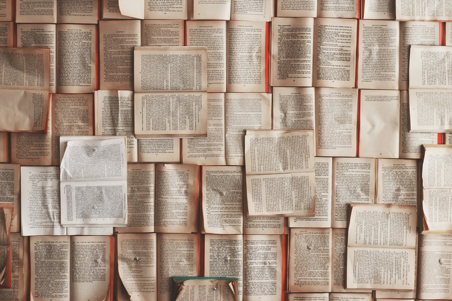 Libros abiertos dispuestos en una superficie, fotografía de Patrick Tomasso