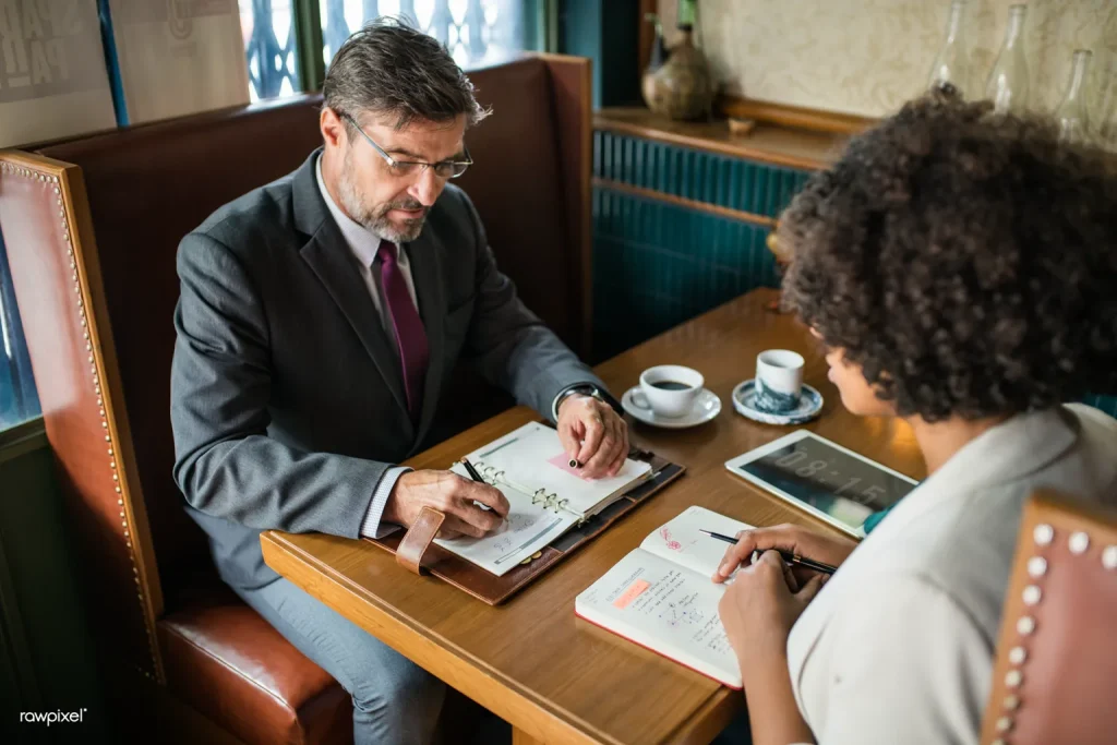 Varias personas conversan alrededor de una mesa en una cafetería